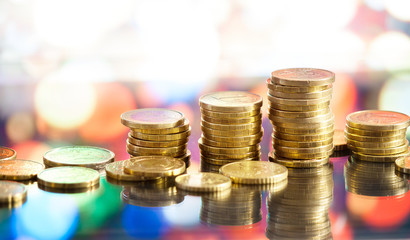 Golden euro coins stacks on bright light glowing bokeh background, business finance wealth and success concept
