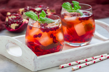 Mojito cocktail with pomegranate, mint, lemon juice and ice in glass, horizontal