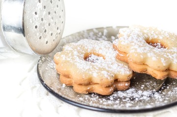 Homemade apricot jam Linzer with icing sugar on the white table close up