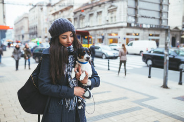 Beautiful brunette young woman holding her adorable Jack Russel terrier. 