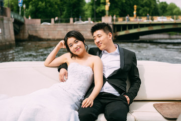 Bride and groom are floating on a boat on the city's rivers and canals