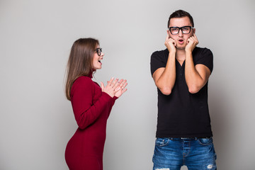 Young woman screaming against a sad young man