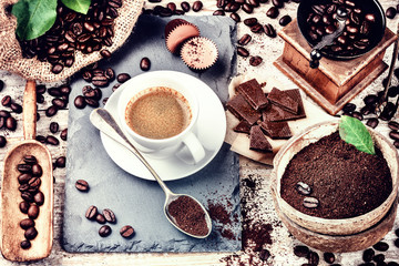 Cup of hot black coffee in setting with roasted coffee beans