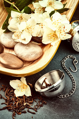 Fototapeta na wymiar Tea infuser with green tea and fresh jasmine flowers