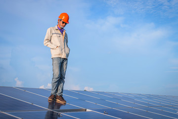 electrician working on checking and maintenance equipment at industry solar power; engineer standing at view point 