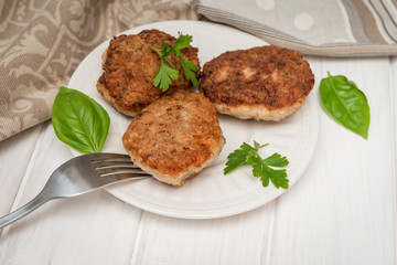 Homemade meat cutlets on white wooden table