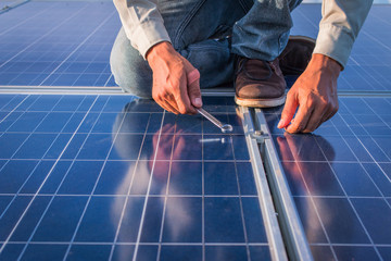 engineer working on checking and maintenance equipment at green energy solar power plant: Wrench...