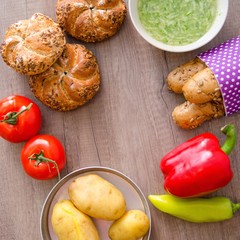 Pepper, potato, kaiser bun and baguette on wood table. Vegetarian bio food concept.