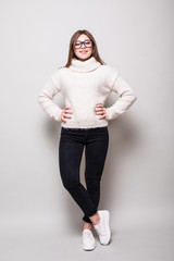 Young woman in sweater in studio. looking away. isolated gray background