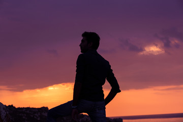 man standing thinking back light sunset lighting side view summer evening beach