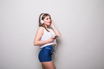 Obraz premium girl listening music with earphones and smartphone isolated on a gray background