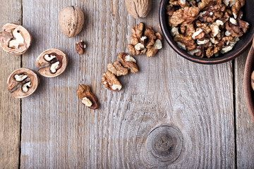 walnuts in a clay plate on a wooden background. top view