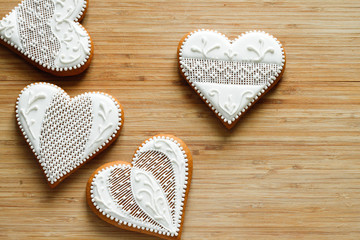 White valentine cookies in the shape of a heart on a wooden background