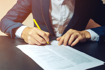 Man businessman signs documents with a pen