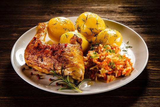 Grilled chicken leg with boiled potatoes and vegetable salad 