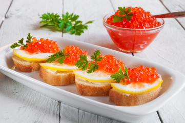 Red caviar on bread with lemon and parsley