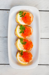 Red caviar on bread with lemon and parsley