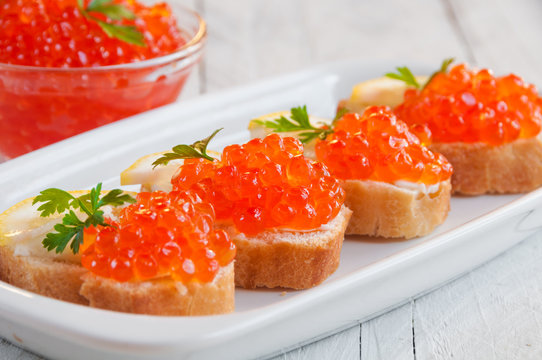 Red caviar on bread with lemon and parsley