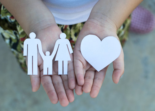 Children hands holding small model of heart and family , concept