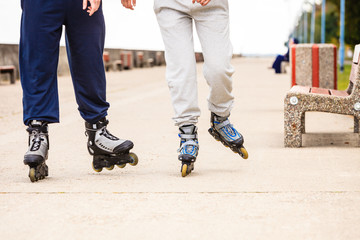 Active people friends rollerskating outdoor.
