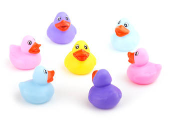 Group of rubber ducks talking together - concept of being friends and including everyone - focus on yellow duckling