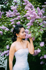 Portrait of young pretty bride surrounded by lilac