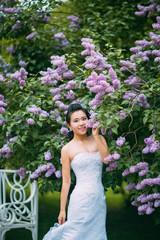 Portrait of young pretty bride surrounded by lilac