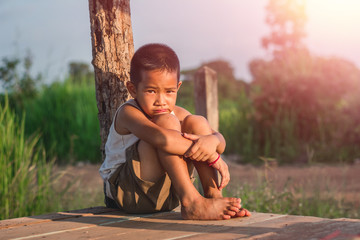 Little boy unhappy sitting alone on abandoned temporary housing.