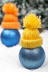 Funny Christmas background with a blue ornament with winter cap, golden gift box, Angels, berries and fir in snow on forest backround