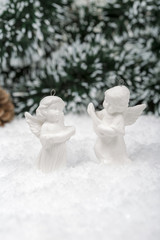 Fototapeta na wymiar Christmas background with beautiful Angels and a red ornament, golden gift box, Angels, berries and fir in snow on forest backround