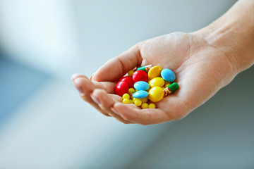 Vitamins And Supplements. Female Hand With Colorful Pills