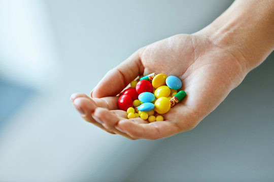 Vitamins And Supplements. Female Hand With Colorful Pills
