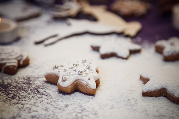 Obraz na płótnie Canvas Christmas gingerbread cookie tree with flour on purple backgroun