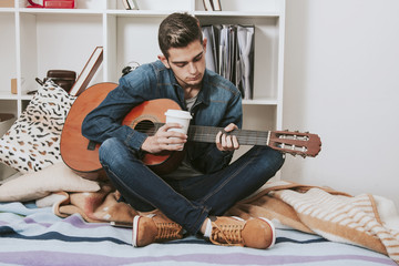 teen in the room playing the guitar