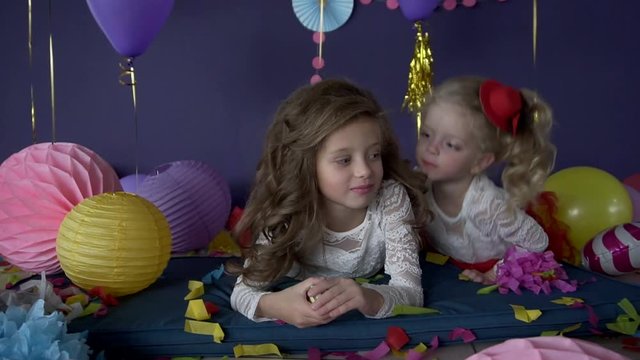 Two pretty baby girls sisters kissing and celebrating on birthday party HD