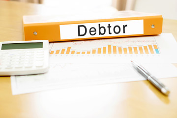Orange  binder debtor on desk in the office with calculator and