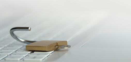 Security concept,open padlock on white keyboard.Computer being protected from online cybercrime and...