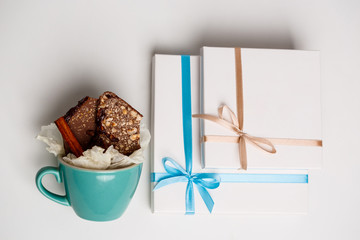 Chocolate in cup and boxes over white background. Above.