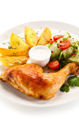 Grilled chicken legs with chips and vegetables isolated on white background