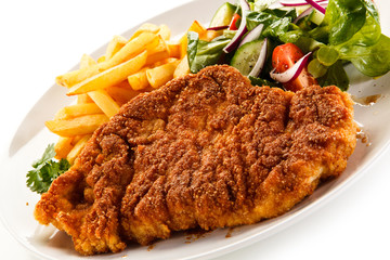 Fried pork chop, French fries and vegetables 