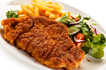 Fried pork chop, French fries and vegetables 