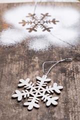 Wooden christmas decoration on brown background with snow