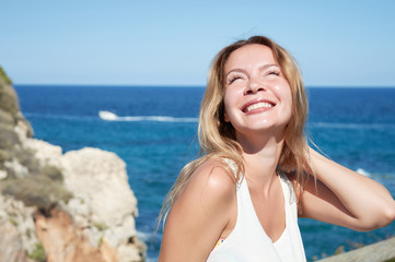 Smiling beautiful blondie girl relaxing on the seacoast