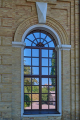 Reflection of blue sky, road, trees and houses in a large window