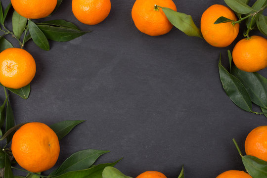 Tangerine fruits on dark table