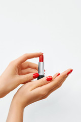 Woman's Hands with Red Nail Polish and Red Lipstick on a White Background