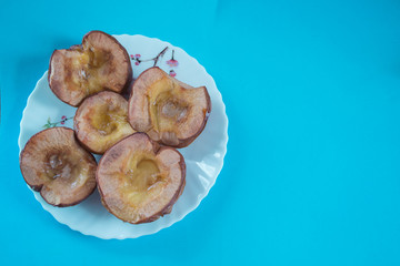 baked quince on a plate on a blue background