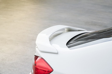 car part ; Close up detail of a custom racing carbon fiber spoiler on the rear of a modern car with copy space
