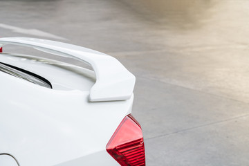 car part ; Close up detail of a custom racing carbon fiber spoiler on the rear of a modern car with copy space

