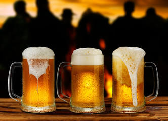 cold glass mug of beer with foam on the background of the street